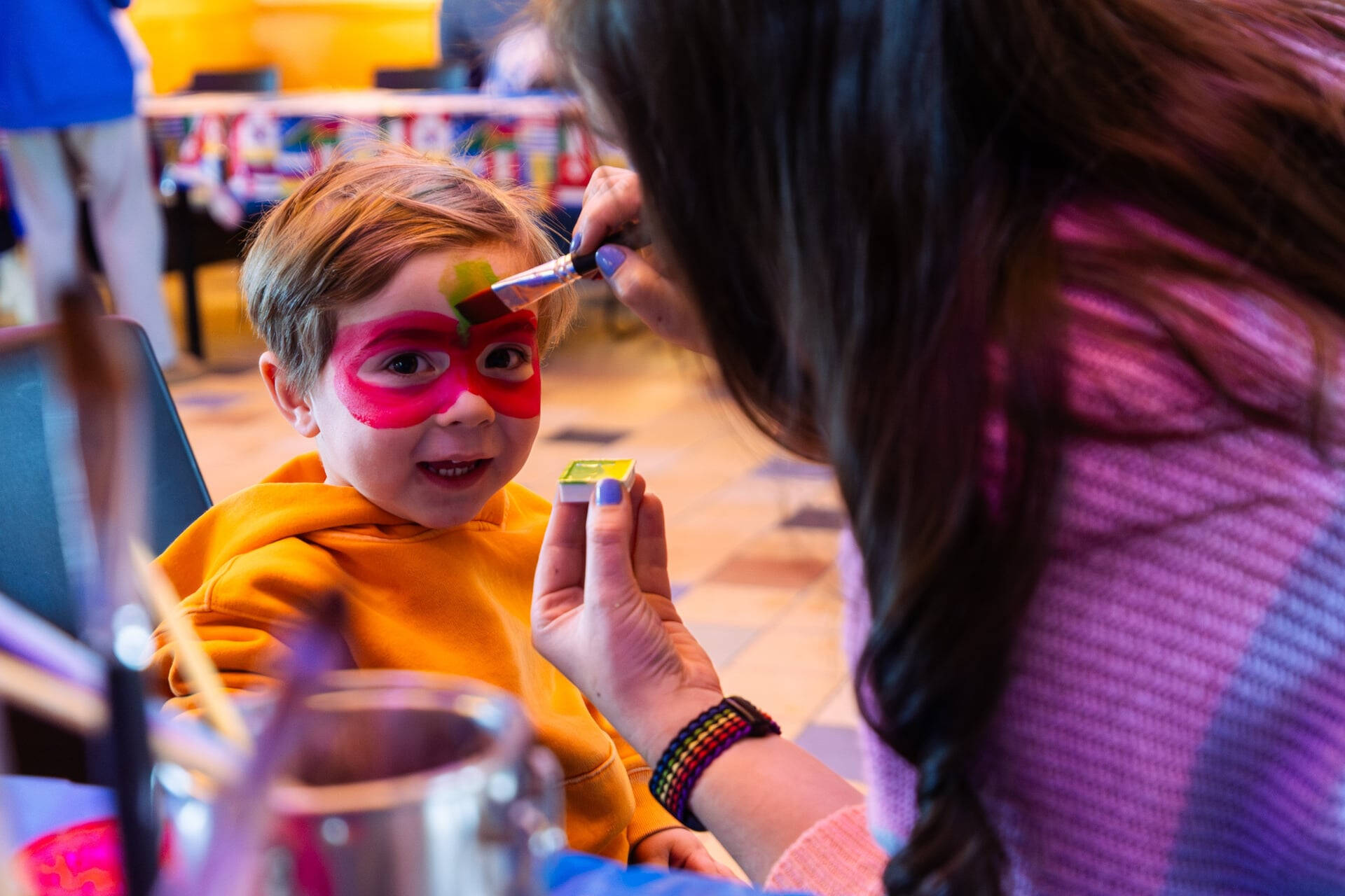 Child getting face painted and smiling